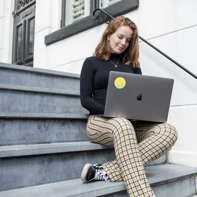 Met een laptop buiten op een trap