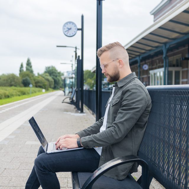 Wachtend op de trein met laptop